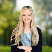 Professional headshot of Emily. She is smiling and looking at the camera, she has long blonde hair.